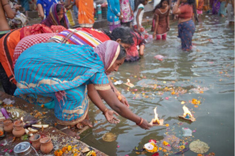 A local woman puts an offering on the water in Varanasi.