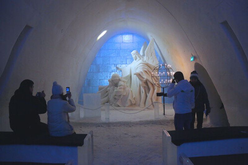 The stunning ice statues, with tourists taking photos at the Snow Castle in Kemi.