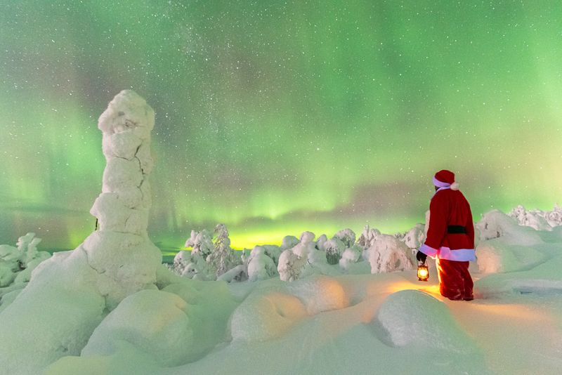 Santa Claus gazing at the Northern Lights in Finnish Lapland—an enchanting highlight of Finland tourism in winter.