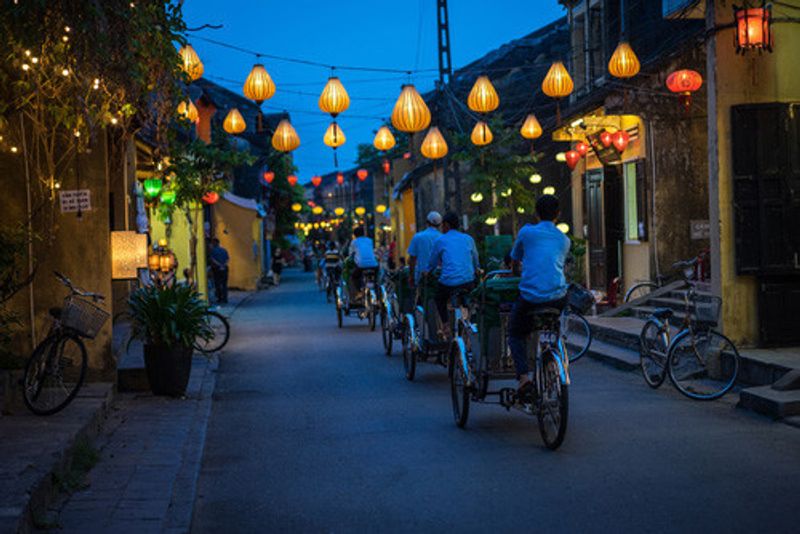 People cycle through Hoi An's lantern filled streets in Vietnam.