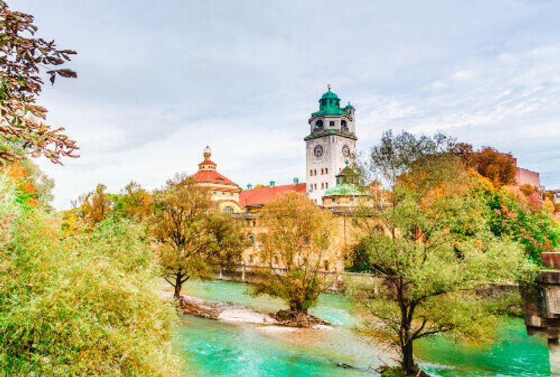 The autumn view of the Isar River with the neo-baroque Muellersches Volksbad in sight.