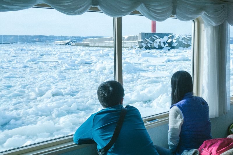 A tourist couple on the Icebreaker ship Aurora watching drift Ice