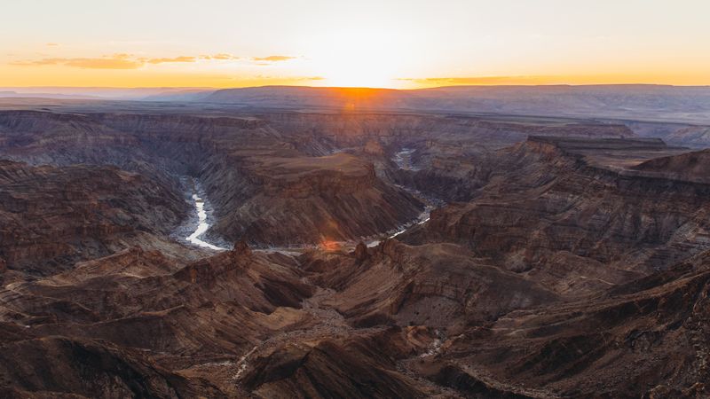 Fish River Canyon sunset casting golden light across one of Namibia’s most dramatic and ancient geological formations.