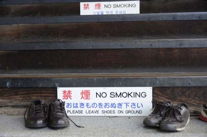 A sign outside a Temple instructs visitors to remove their shoes.