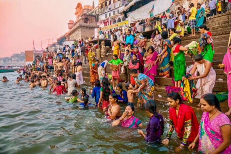 A crowd gathers and bathes in the meaningful Ganges River.