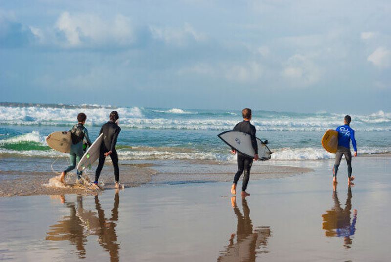 Surfers walking down Banana Beach, on the Mediterranean Sea in Tel Aviv, Israel.