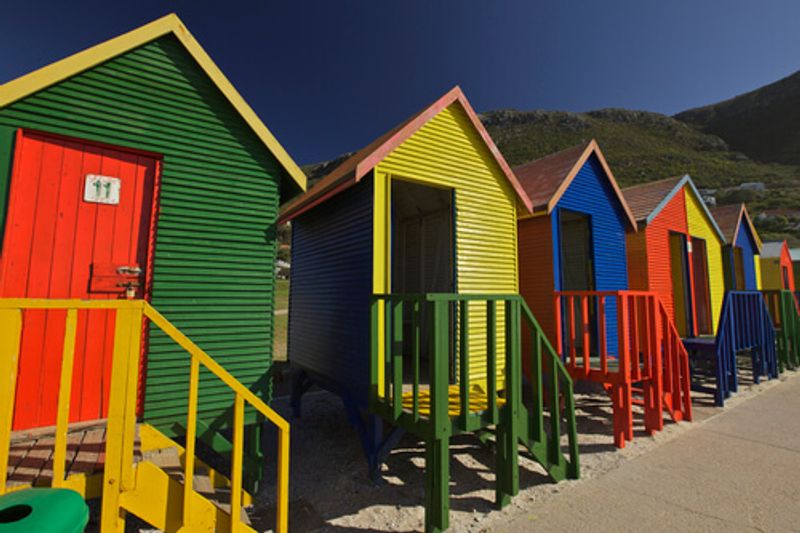 Beach huts line the shore of beaches in Cape Town.