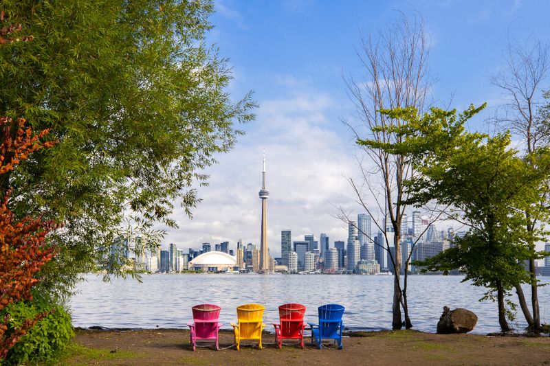 View of the CN tower and Lake Ontario with four colourful chairs.