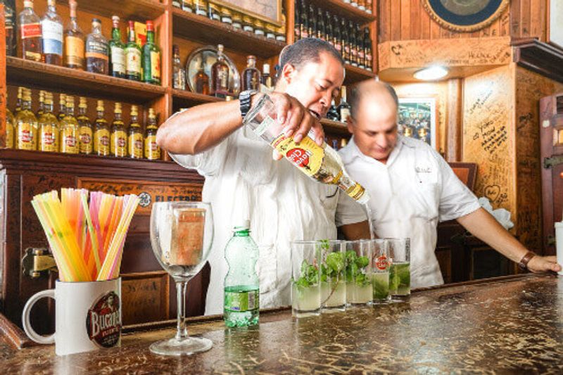 Professional Cuban bartenders preparing mojitos at the world famous cocktail bar Bodeguita del Medio in Havana.