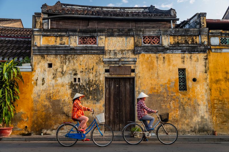 Morning light in Hoi An’s Old Town as local women start their day—peaceful scenes far removed from the Vietnam War era