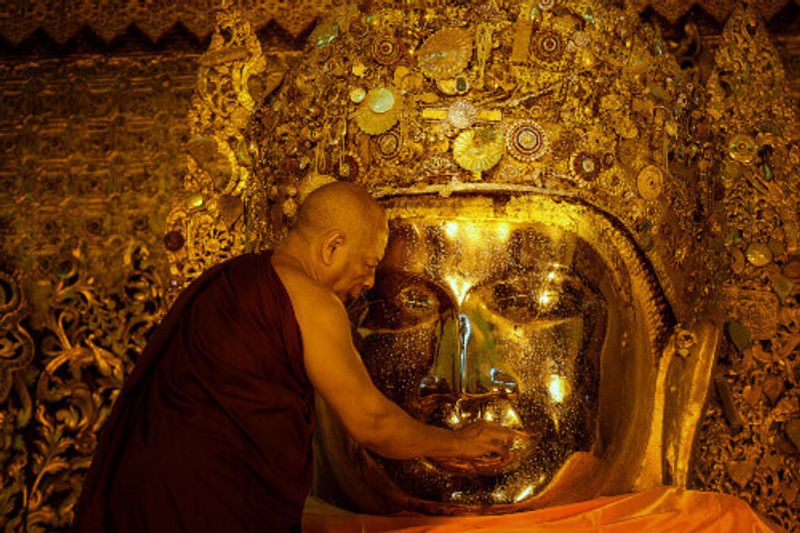 A ritual in which a monk washes the face of the Mahamuni Buddha in the Myat Mahamuni Temple.