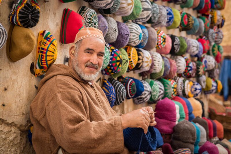 A local man sells hats in a Morrocan market.