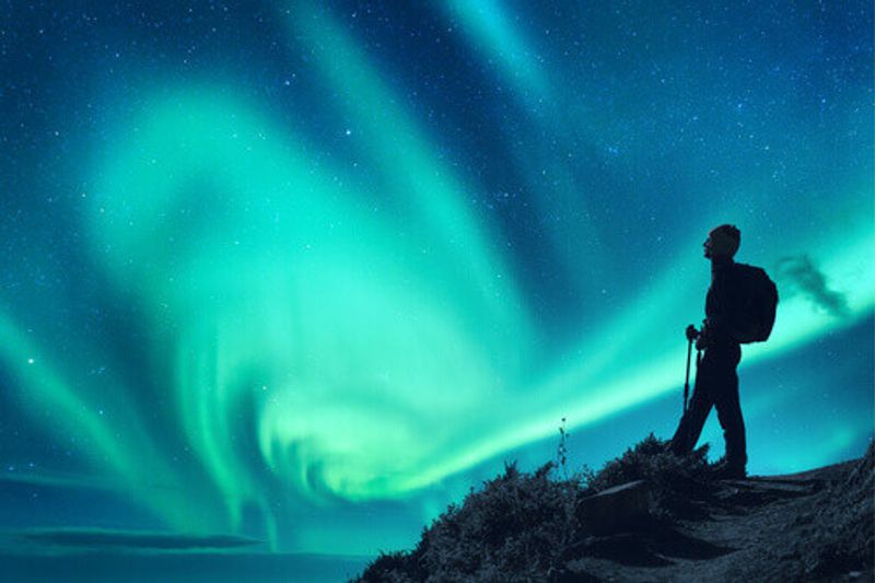 The silhouette of a woman against the Northern Lights in Norway.