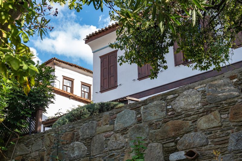 The old Nisanyan Evleri Hotel with wooden brown windows.