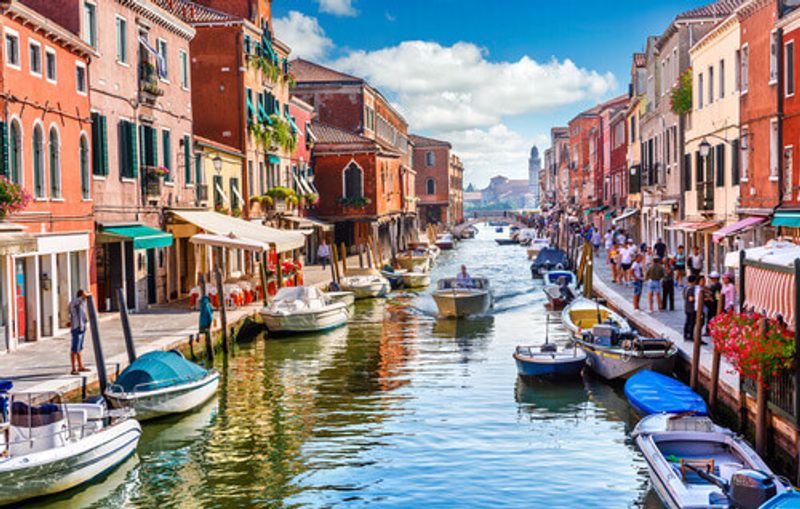 The island of Murano with canals and boats in view.