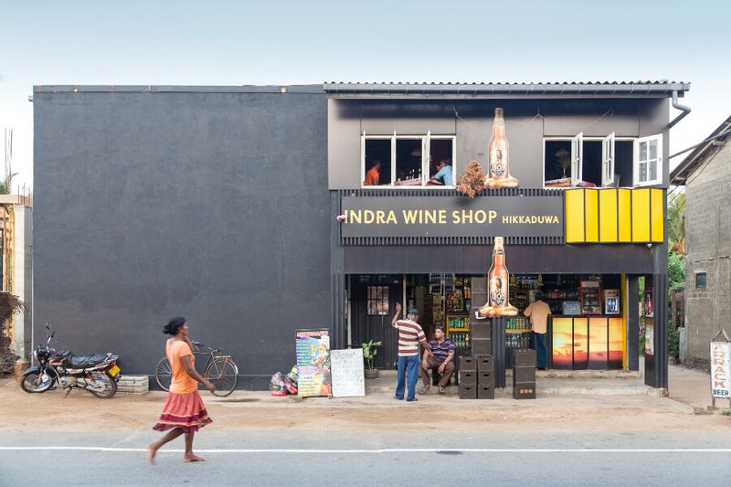 Locals in front of the Indra Wine Shop in Hikkaduwa, Sri Lanka.