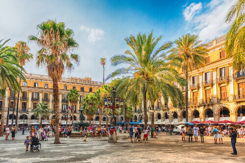 People walking in the Placa Reial or Plaza Real, a scenic and iconic square of the Gothic Quarter.