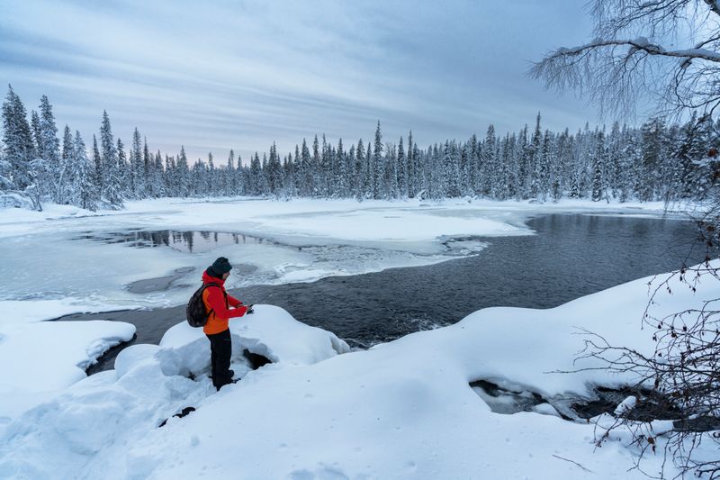 Ice fishing on a frozen lake in Finland is a peaceful winter pastime and a highlight of Finnish tourism. 