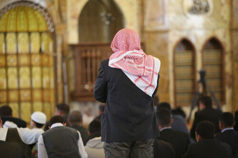 A man prays with others inside a Mosque in Amman.