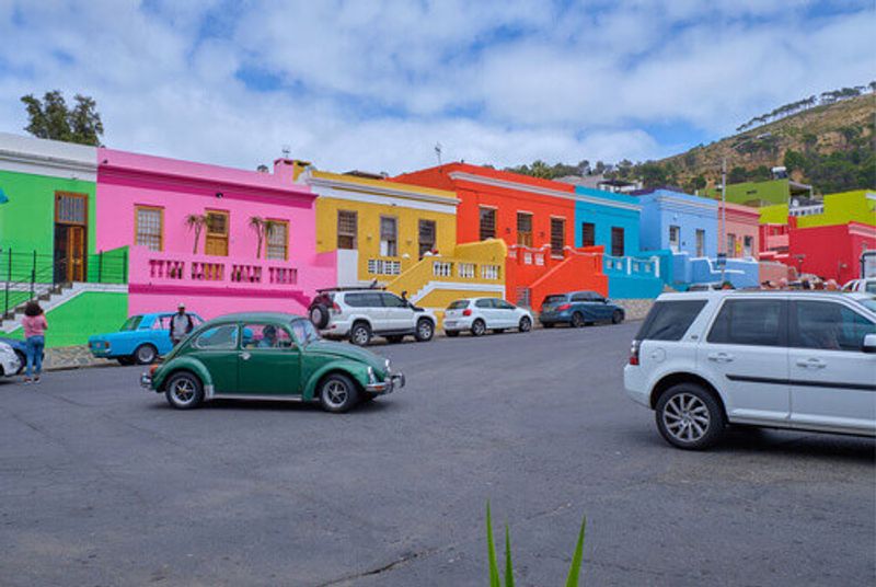 Car on the main street featuring colourful facades of the houses in Bo Kaap, Cape Town.