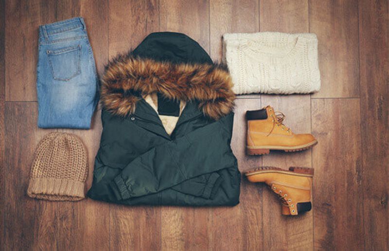 An array of female winter clothes against a wooden background.