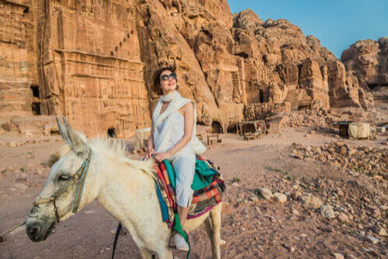 A female tourist rides a donkey in Nabatean, Petra.