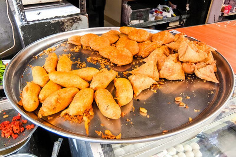 Common Indian streetfood, Kachori and Mirchi Vada on a platter in the streets of Jodhpur.