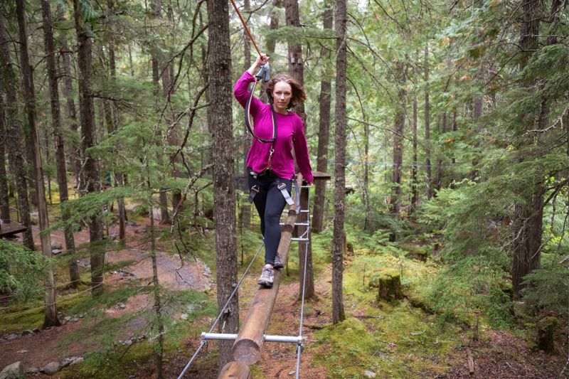 Woman on an Ecotour going up the trail for a zip line ride.