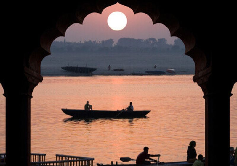 A small boat on the Ganges River at sunset.