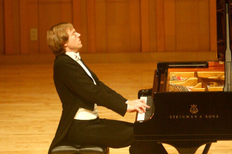 Professor Jan Jiracek von Arnim playing a piano on stage.