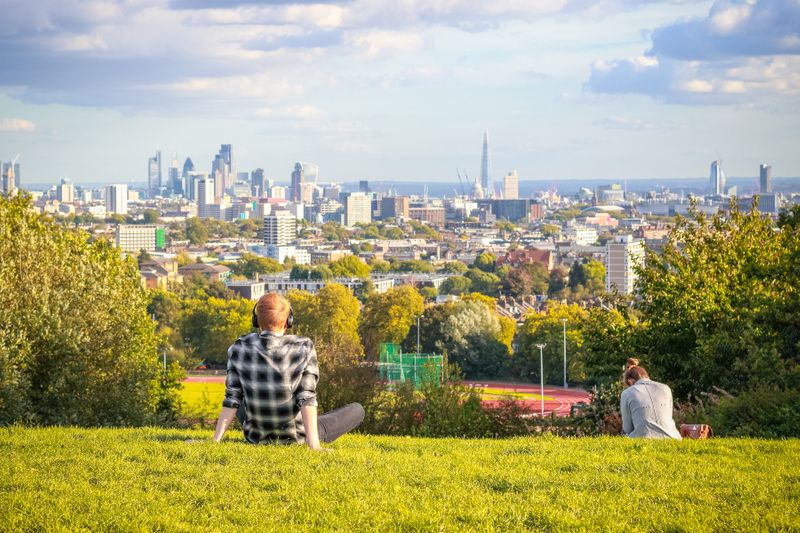 A visitor looks over London City from Parliament Hill in Hampstead Heath.