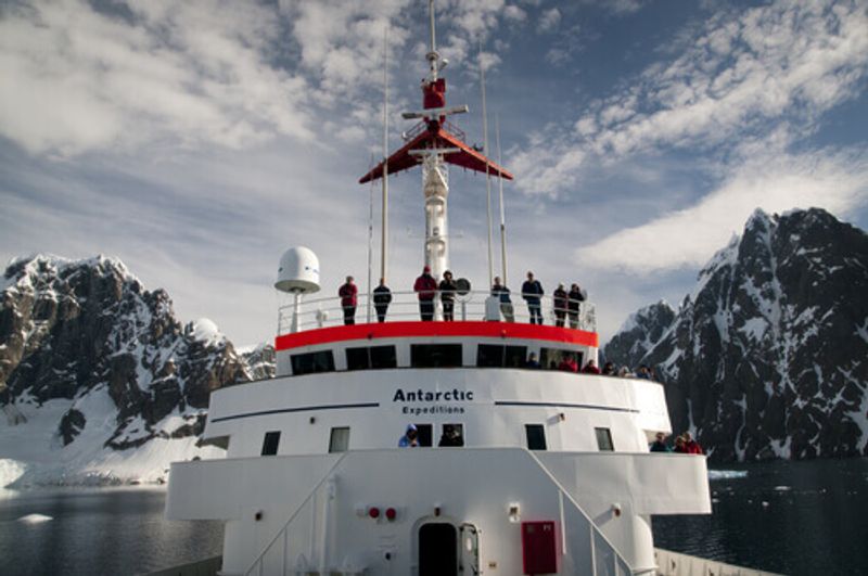 People watch from the stern of a ship in Antarctica.