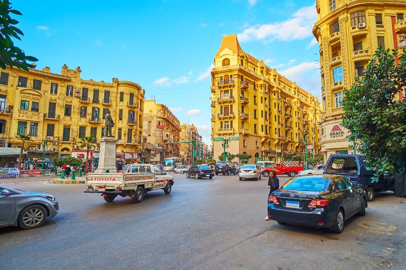The busy traffic on Talaat Harb Square with a view of historical mansions in the background.