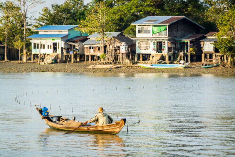 Burmese fisherman netting fish in a river.