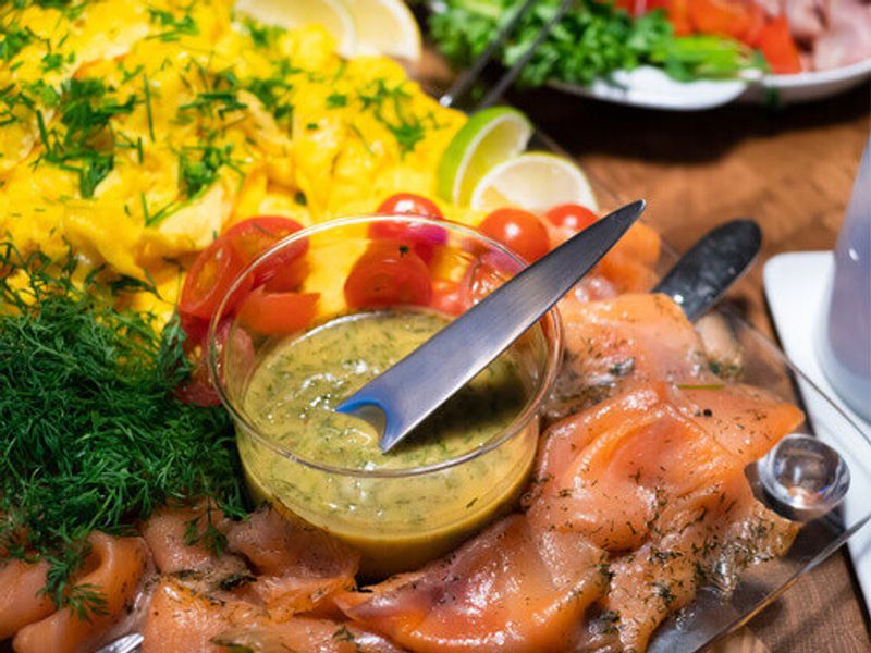Scandinavian smorgasbord with gravlax and mustard sauce, dill, salmon and scrambled eggs.