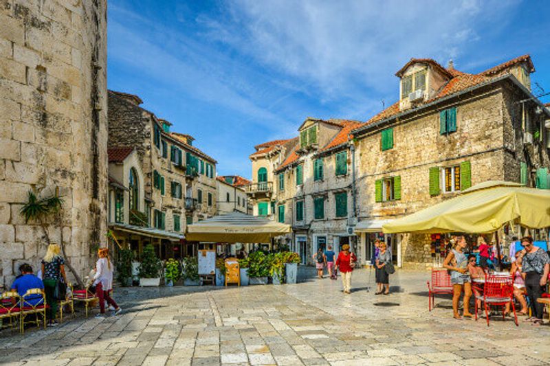 Tourists enjoy cafe's and shops on an early autumn afternoon on the Fruit Square in the Diocletians Palace section of Old Town Split.