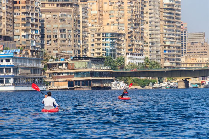 Male and female tourists kayaking on the Nile River.
