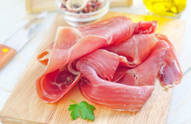 Proscuitto di Parma served on a wooden board.