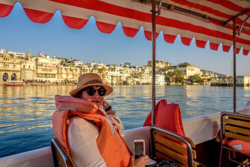 Tourist on a boat trip across Lake Pichola overlooking the City Palace.