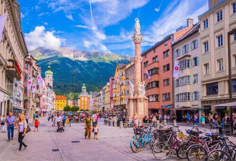 Locals and tourists passing through the town square dominated by St. Annas column in Innsbruck.