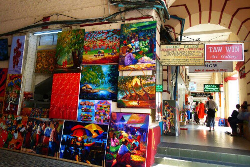 Taw Win Art Gallery at Bogyoke Market with people walking around in Yangon.