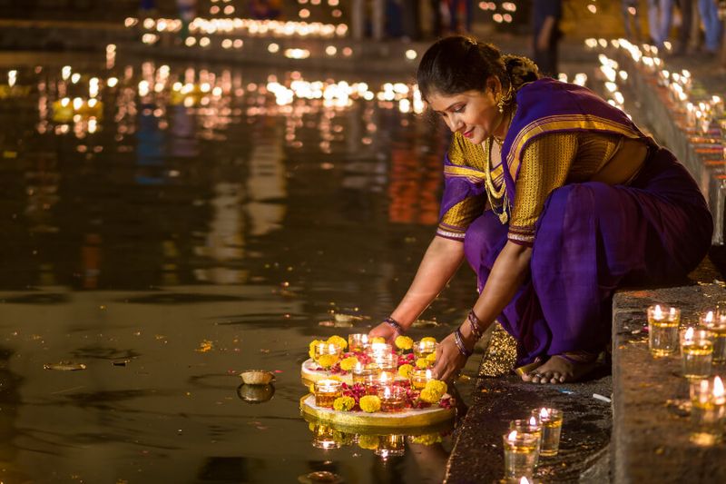 A woman lights diya during Diwali in Mumbai