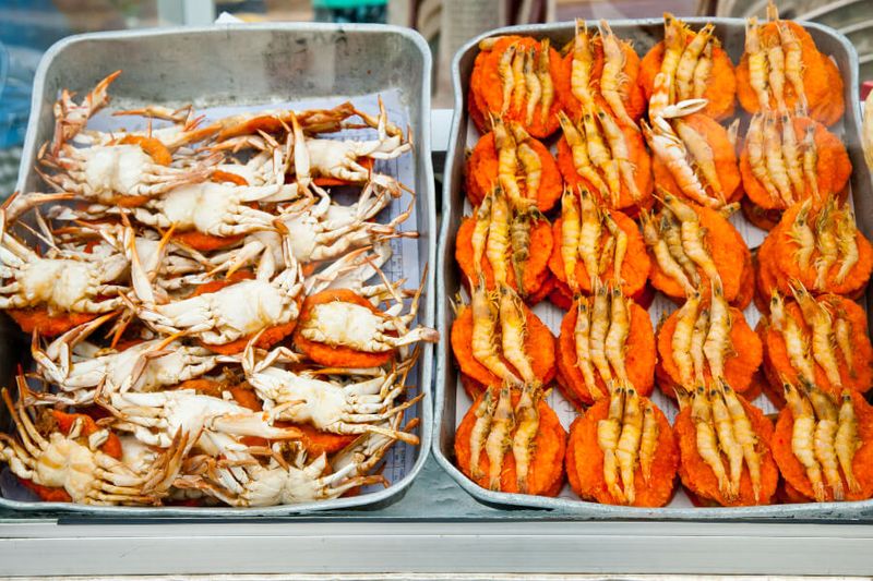 Spicy flat cakes and crabs on display in a food stall.