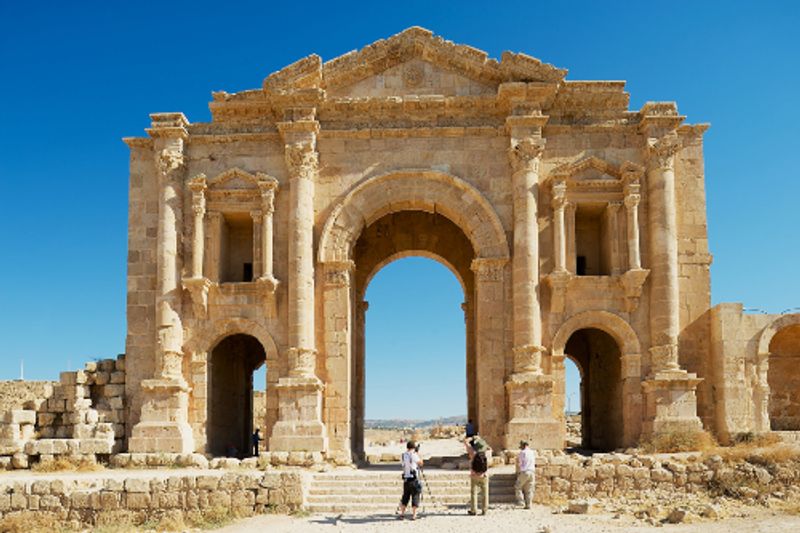 Tourists visiting the arch of Hadrian in the ancient Roman city of Gerasa in Jerash, Jordan.