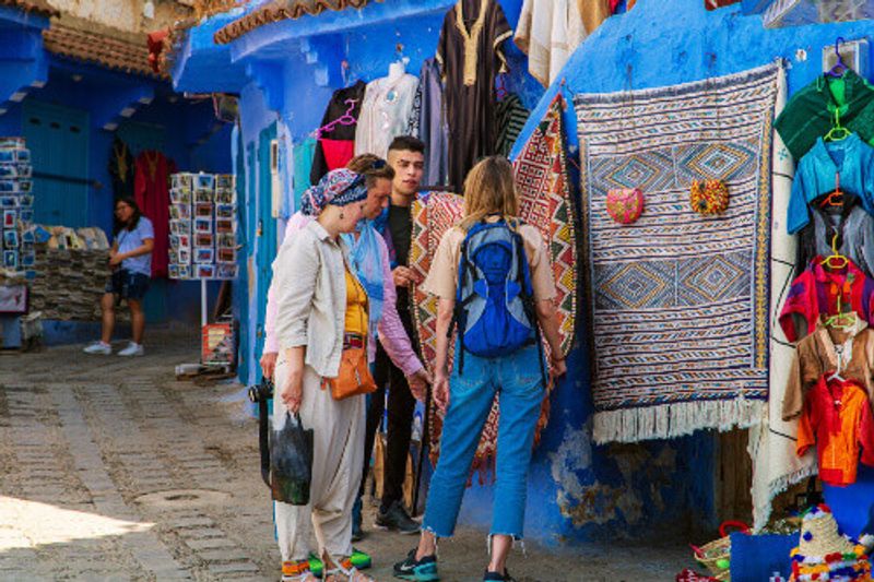 Tourists bargaining at the market in the blue city of Chefchaouen.