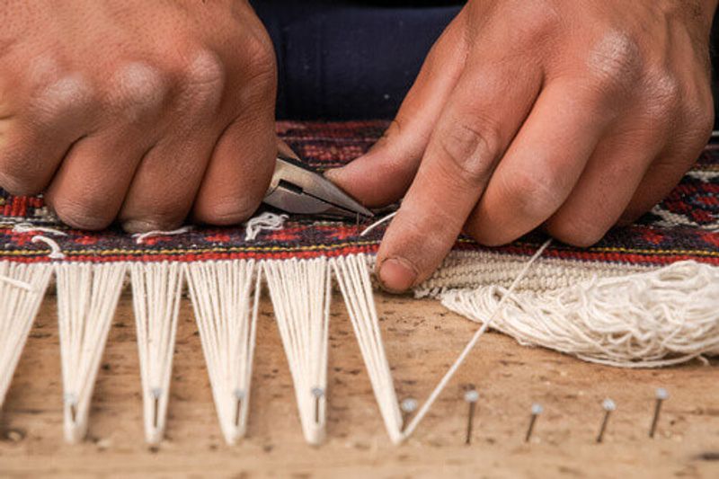 Man weaving a traditional handmade carpet in Isfahan.