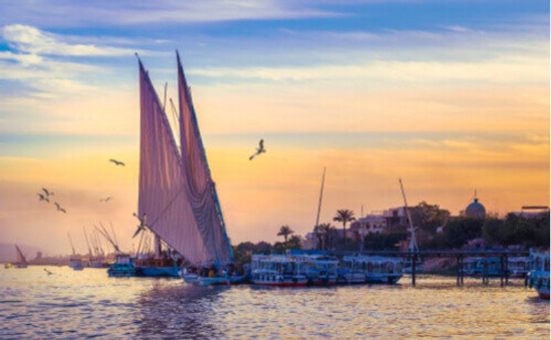 Felucca sailing on the Nile during sunset in Egypt.