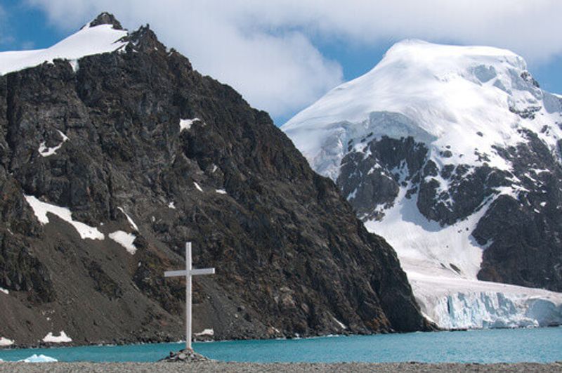 A memorial to explorers and sailors that overlooks glacial mountains in the South Orkney Islands, Antarctica.