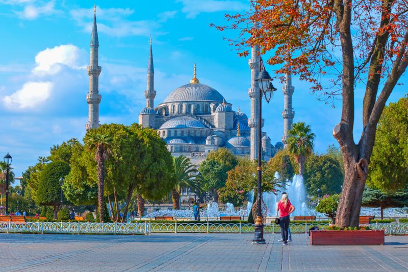 A female tourist admiring the Blue Mosque from the Sultan Ahmet Square.