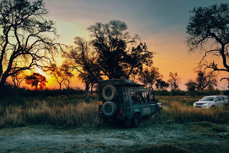 An old fashioned vehicle pulls an SUV out of a swamp at the Moremi National Park in Okavango Delta.